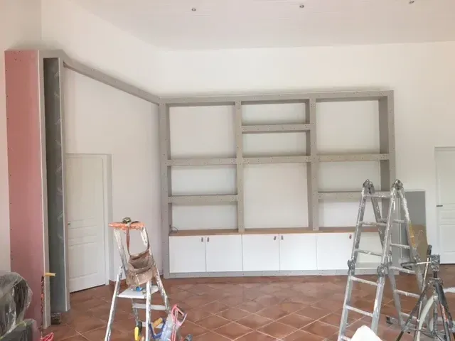 Grande bibliothèque murale en BA13 sur mesure, en cours de montage